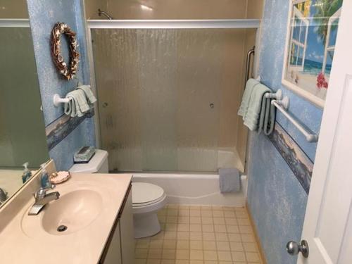 a bathroom with a sink and a toilet and a shower at Wailua Bay View Resort in Kapaa