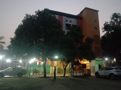 a person standing in a parking lot at night at Kuber's Residency in Mahad