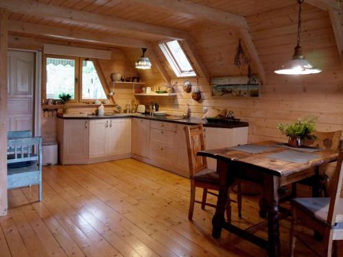 a kitchen with a wooden floor and a wooden table at Domek w Brzozach in Sasino