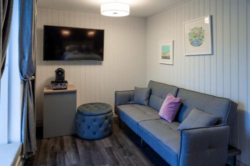 a living room with a blue couch and a tv at The Three Crowns B&B in Plymouth