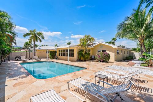 a house with a swimming pool and palm trees at Edens Reef, Three configurations to choose from, Lauderdale by the Sea, FL in Fort Lauderdale