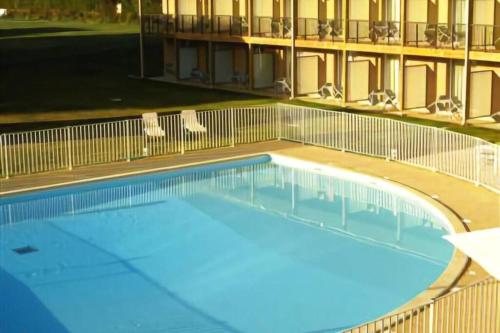 une grande piscine devant un immeuble dans l'établissement Le Maurifleur vous accueille à 3 km de Honfleur, à Équemauville