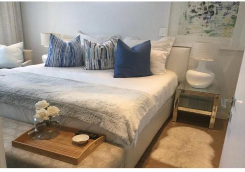a bedroom with a bed with blue and white pillows at One Hyde Park Sandton in Johannesburg