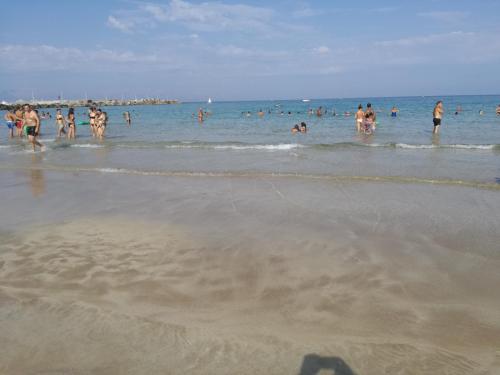 a group of people in the water at the beach at Terra Sinus Beautiful Suite in Terrasini
