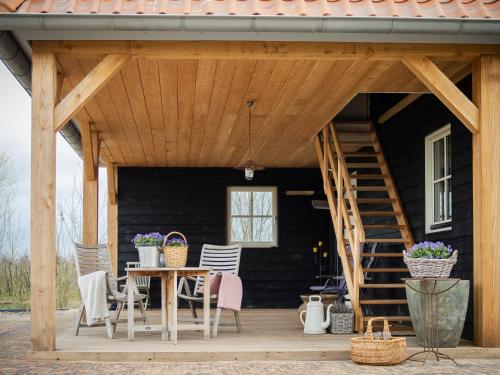a wooden porch with a table and chairs at Landgoed het Heuvelbosch in Waardenburg