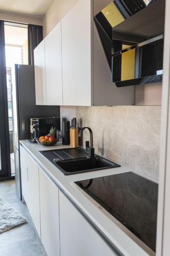 a kitchen with white cabinets and a black sink at Port of Travemünde, Opening 2021 in Travemünde