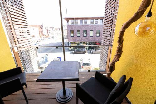 a balcony with a table and a view of a street at Port of Travemünde, Opening 2021 in Travemünde