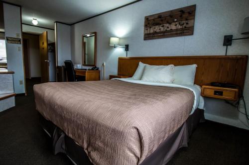 a bedroom with a large bed in a hotel room at Companion Hotel Motel in Hearst