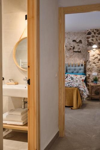 a bathroom with a sink and a bed in a room at Apartamentos Cortijo Peñardera in Siles