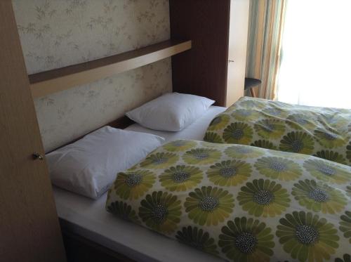 2 Betten in einem Zimmer mit zwei Kissen darauf in der Unterkunft Garni Hofer in Sexten