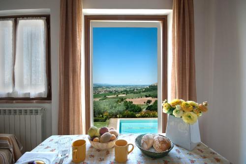 a table with a vase of flowers and a window at Agriturismo Fiordaliso in Trevi