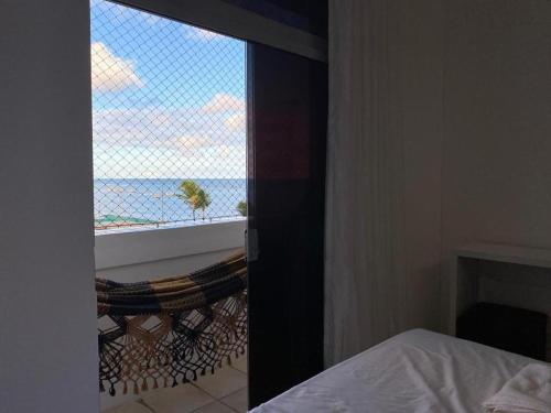 una camera da letto con finestra con vista sull'oceano di Flat beira mar, Olinda 4 Rodas 313 a Olinda