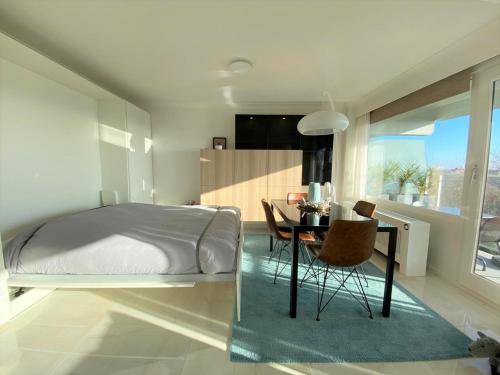 een slaapkamer met een bed, een tafel en stoelen bij La Perle d´Ostende in Oostende