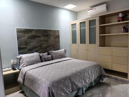 a bedroom with a bed and a book shelf at Casa Sandy in Cozumel