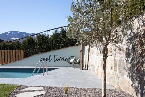 a tree sitting next to a swimming pool at Garni-Hotel mir.es in Tirolo