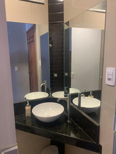 a bathroom with three sinks and a large mirror at Studio miguel II in Rio de Janeiro