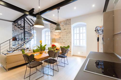 een keuken en een woonkamer met een tafel en stoelen bij Old Town Luxury House in Split