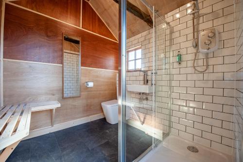 a bathroom with a glass shower and a toilet at Oakside Tree Tops in Canterbury