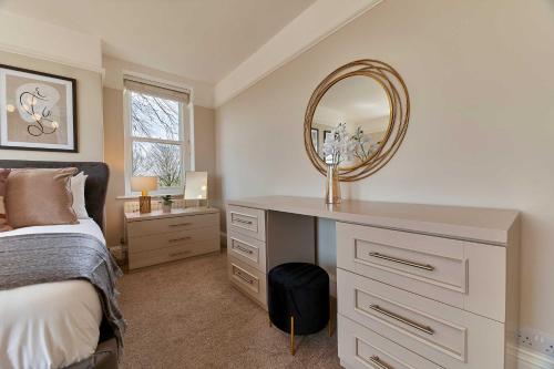 a bedroom with a bed and a mirror on a dresser at Host & Stay - The Old Rectory in Witton Gilbert