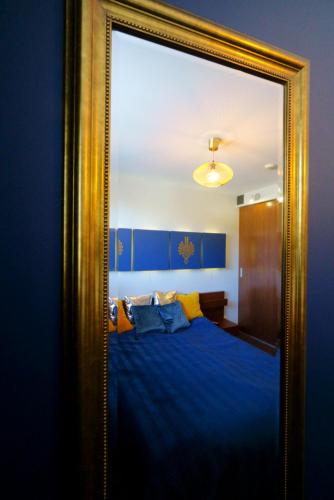 a mirror in a bedroom with a blue bed at Apartament Oaza in Kościelisko