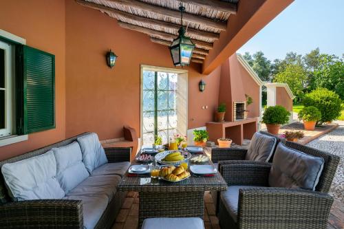 a patio with couches and a table with fruit on it at Quinta das Figueiras - Bordeira - Faro in Bordeira