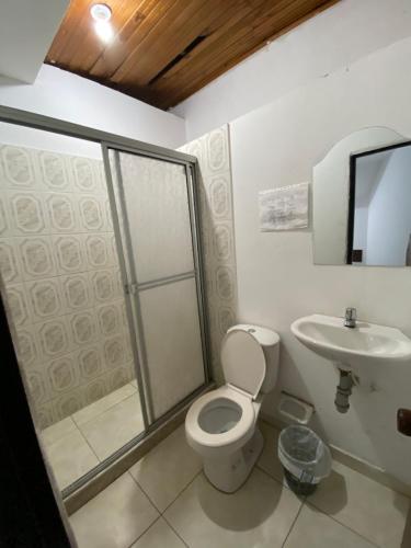 a bathroom with a toilet and a sink at Hotel Policarpa in Guaduas