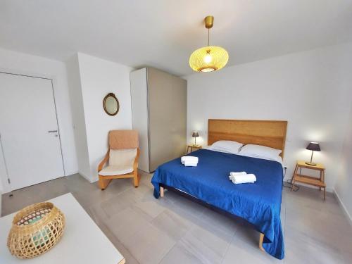 - une chambre avec un lit bleu et une chaise dans l'établissement Appartement CATALINA - Double terrasse - WIFI - Clim - PORTICCIO, à Porticcio