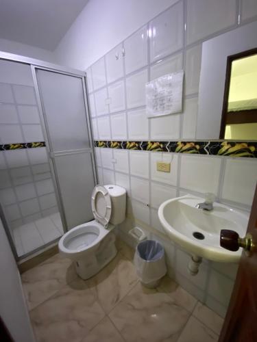 a bathroom with a toilet and a sink at Hotel Policarpa in Guaduas