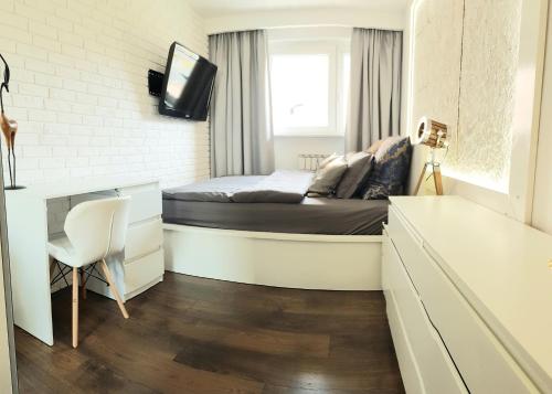 Habitación pequeña con cama y escritorio. en Apartament Modrzewskiego, en Grudziądz