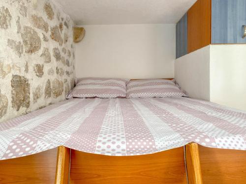 a bedroom with a bed with pink and white sheets at City center apartment Roza in Makarska