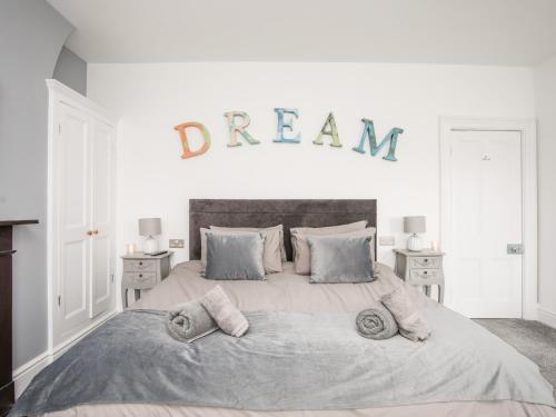 a bedroom with a large bed with a dream sign on the wall at Lluest in Beaumaris