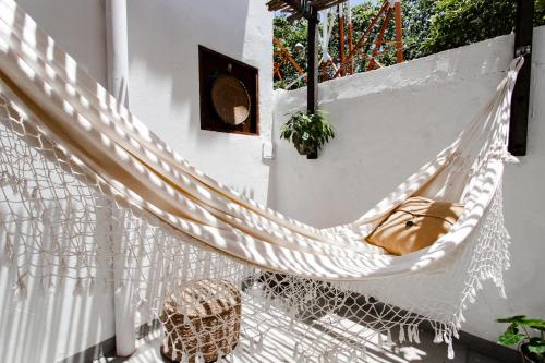 a hammock on a balcony with a bag at Jeri Pousada in Jericoacoara