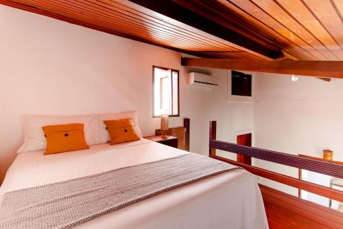 a bedroom with a white bed with orange pillows at Jeri Pousada in Jericoacoara