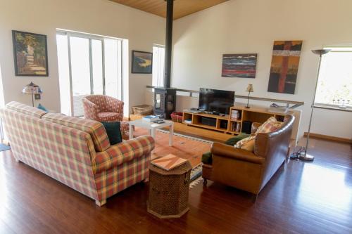 ein Wohnzimmer mit 2 Sofas und einem TV in der Unterkunft QUINTA DOS MONTEIROS - 3 Quartos com Piscina in Resende