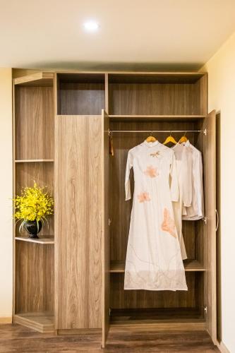 a wooden wardrobe with a dress in it at LA MIA Lakeview Hotel in Pleiku
