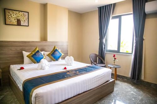 a bedroom with a large bed with a window at LA MIA Lakeview Hotel in Pleiku