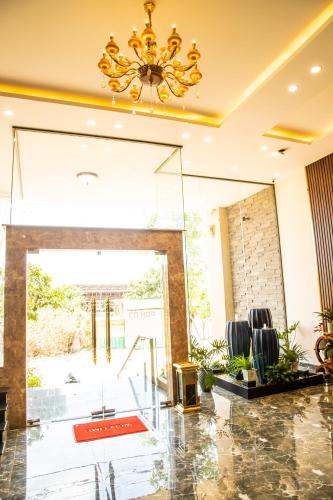 a lobby with a chandelier and chairs in a building at LA MIA Lakeview Hotel in Pleiku
