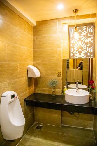 a bathroom with a sink and a mirror at LA MIA Lakeview Hotel in Pleiku