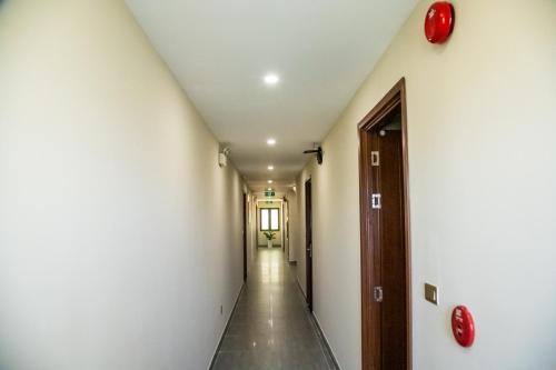 a corridor of a hallway with white walls and a door at LA MIA Lakeview Hotel in Pleiku