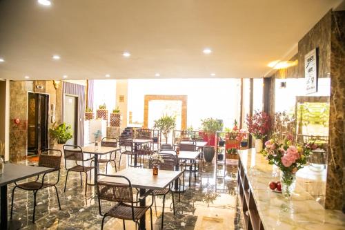 a restaurant with tables and chairs in a room at LA MIA Lakeview Hotel in Pleiku