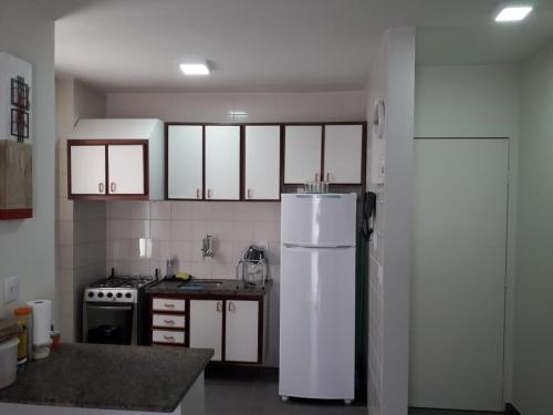 a kitchen with a white refrigerator and a stove at Residencial Thermas Caldas in Caldas Novas