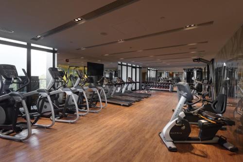 Crowne Plaza Tainan, an IHG Hotel في آنبينغ: صالة ألعاب رياضية مع صف من أجهزةالجري وأجهزة القلب