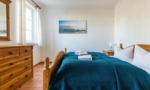 ein Schlafzimmer mit einem Bett mit einer blauen Decke in der Unterkunft Friederike in Ahrenshoop