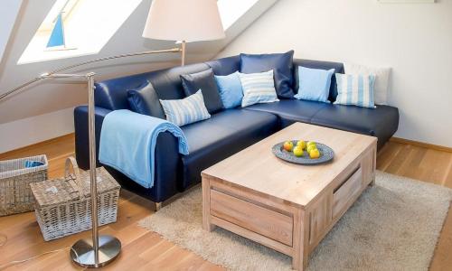 a blue couch in a living room with a table at Am Kranichland in Wieck