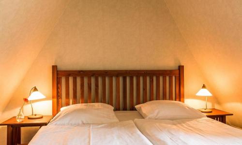a bedroom with a large bed with two lamps at Meermaler in Ahrenshoop