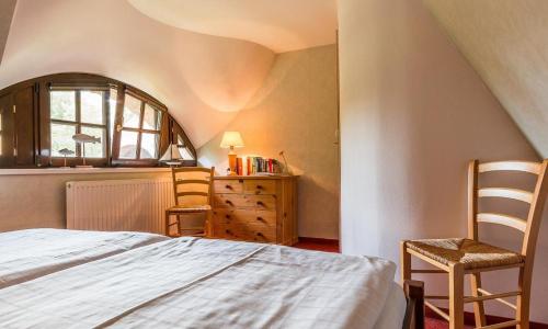 um quarto com uma cama, 2 cadeiras e uma cómoda em Meermaler em Ahrenshoop