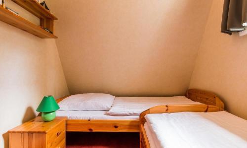 a bedroom with two twin beds and a green lamp at Meermaler in Ahrenshoop