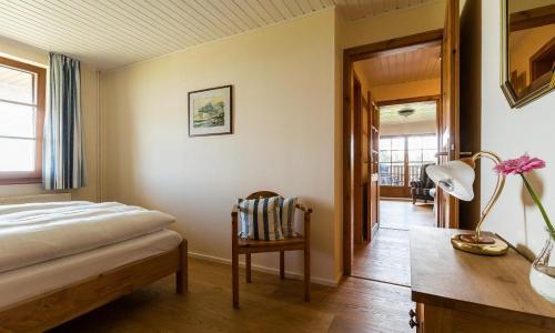 a bedroom with a bed and a table and a chair at Haus am Bodden 03 in Ahrenshoop