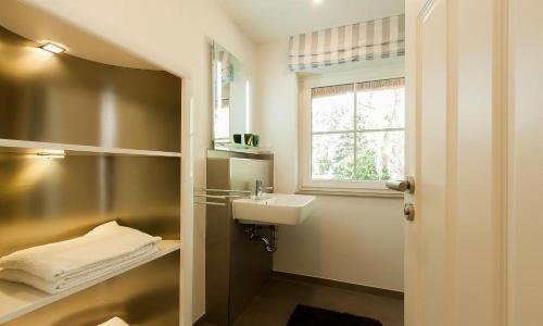 a bathroom with a sink and a window at Haus Schilfkante - Wohnung 1 in Wieck