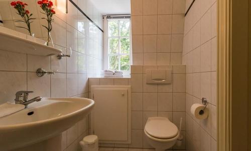 een witte badkamer met een wastafel en een toilet bij Villa Sonnenfrieden 02 in Ahrenshoop